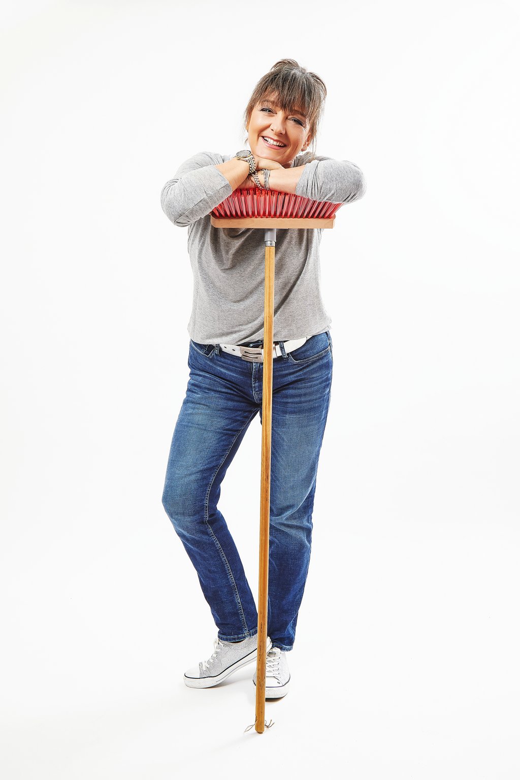 Auf dem Bild ist Rena Schwarz auf einen Besen gestützt zu sehen..