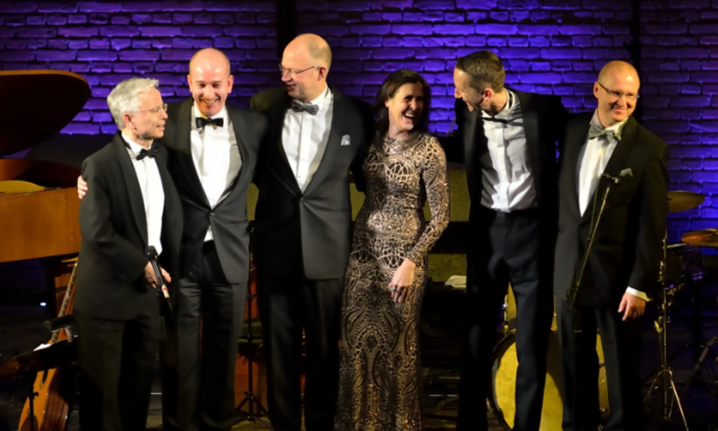 Auf dem Bild sind die fünf Musiker von Chris Hopkins und Sängerin Shaunette Hildabrand in Abendrobe zu sehen.