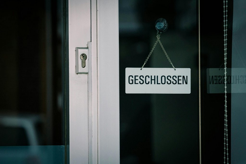 Weiße Doppelflügeltür, an der ein Schild mit dem Aufdruck „geschlossen“ hängt.