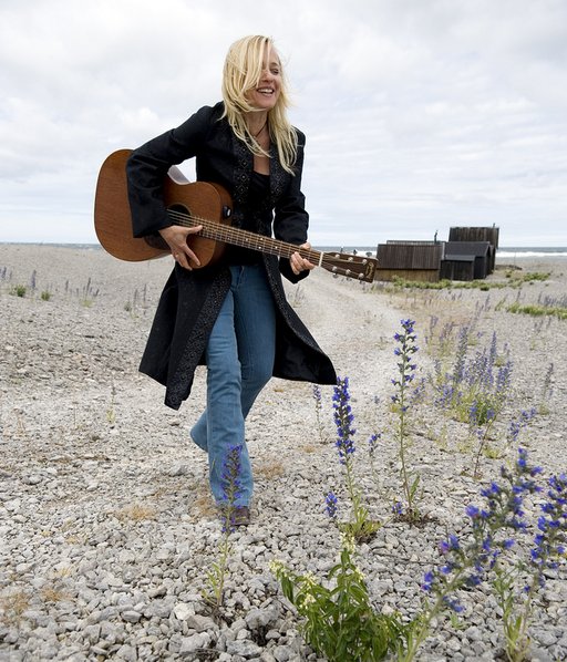 Auf dem Bild ist Annika Fehling mit Gitarre am Strand zu sehen.