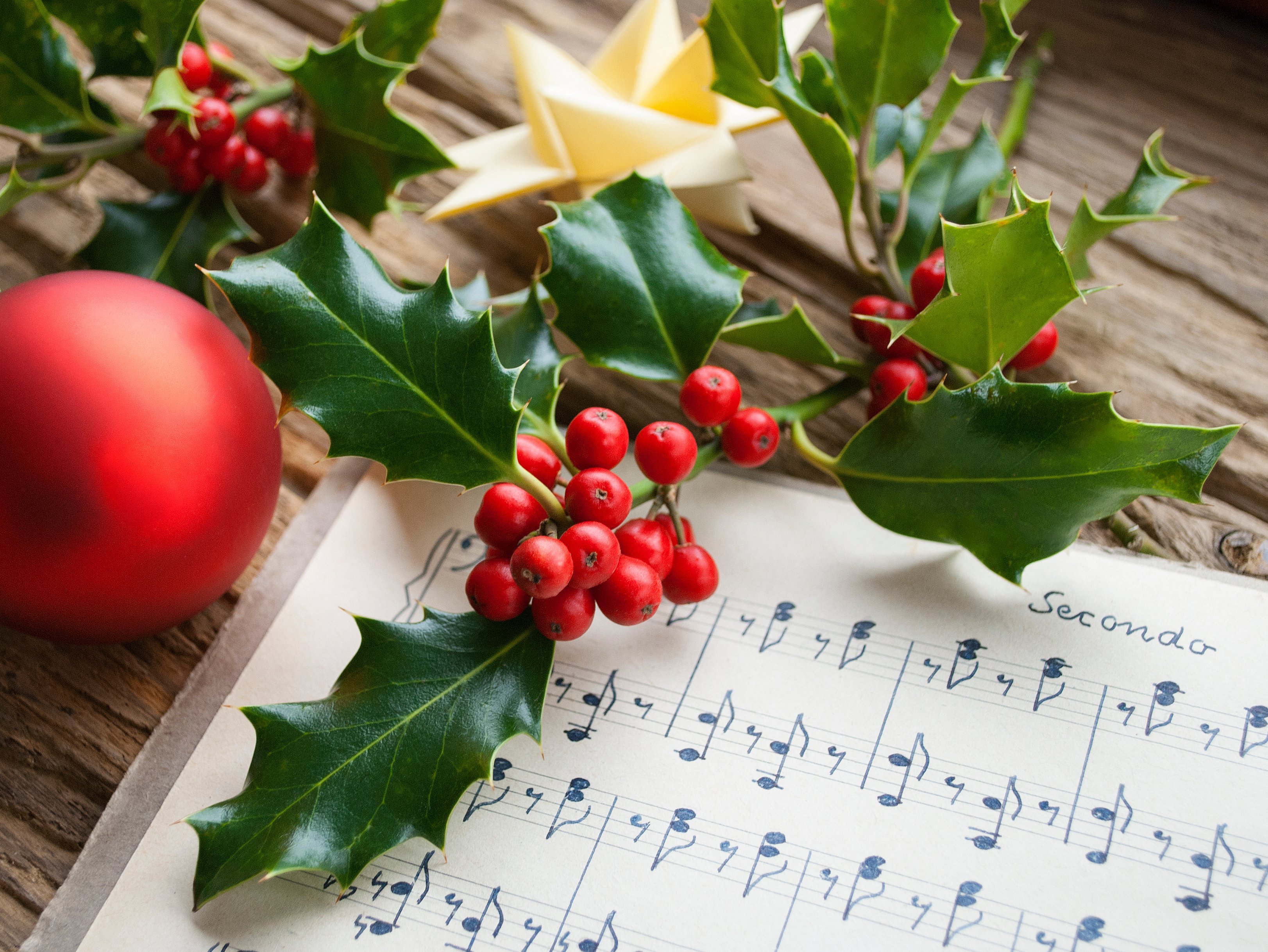 Weihnachtsschmuck liegt auf einem Tisch, darunter liegen Noten