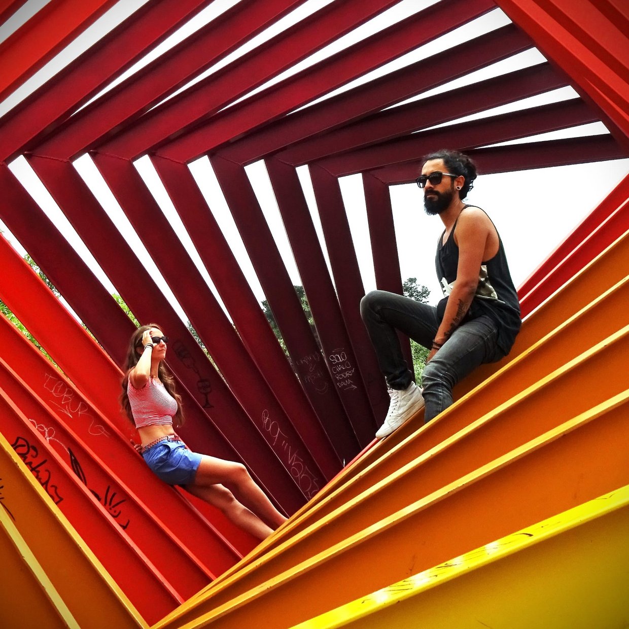 Auf dem Bild sind die beiden Musiker von SolyMar in einer gelb-roten Skulptur sitzend zu sehen.