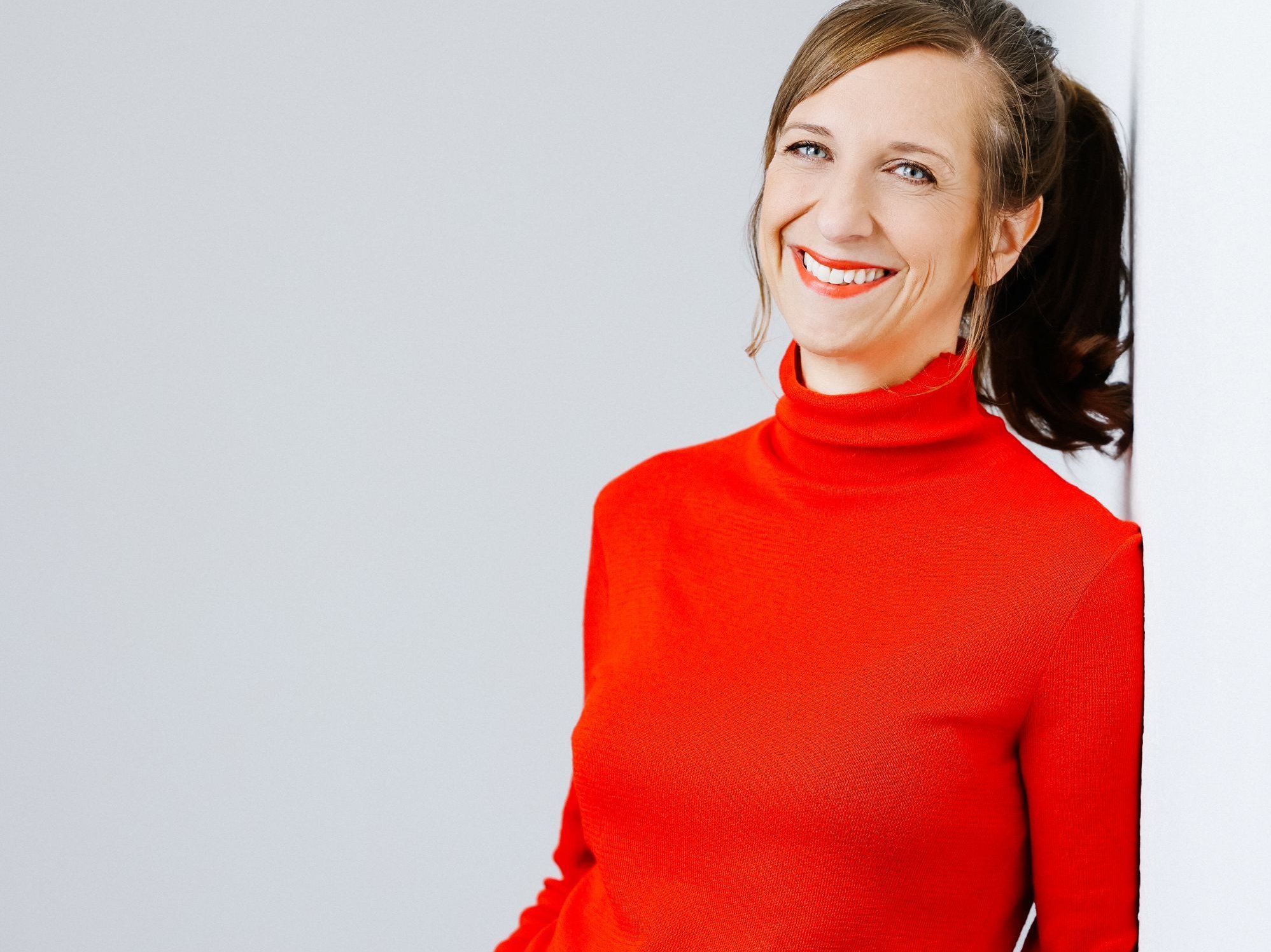 Auf dem Bild ist Sarah Hakenberg in rotem Pullover zu sehen.