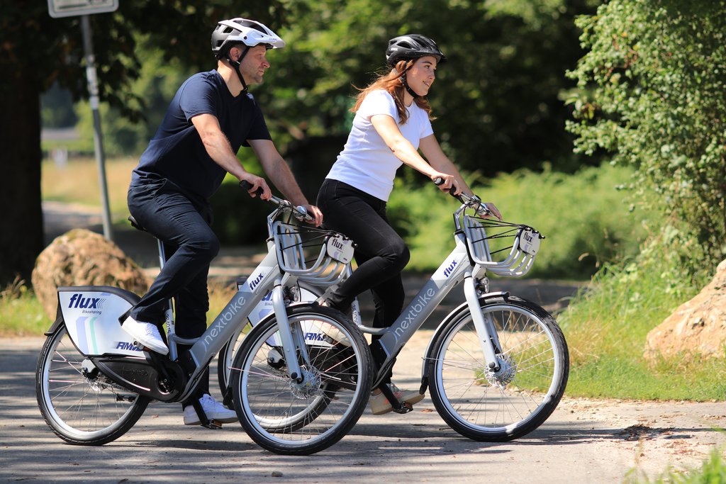 Das Bild zeigt zwei Personen, die auf E-Bikes des RMV-Angebots "flux" unterwegs sind.