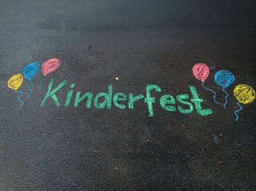 mit Kreide gemalter Schriftzug Kinderfest, eingerahmt von gemalten Luftballons