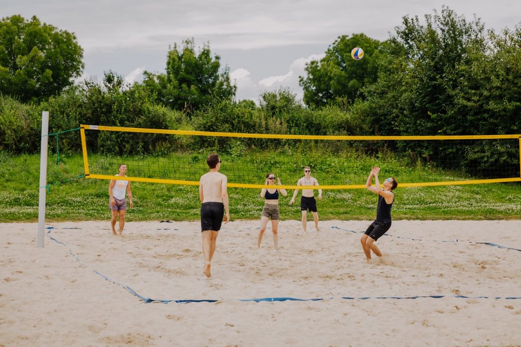 Das Bild zeigt Menschen, die Beachvolleyball spielen..