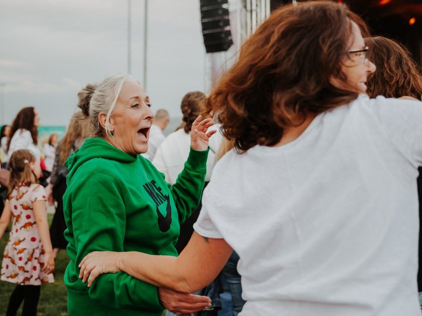 Das Foto zeigt Menschen, die vor der Bühne im Sportpark tanzen.