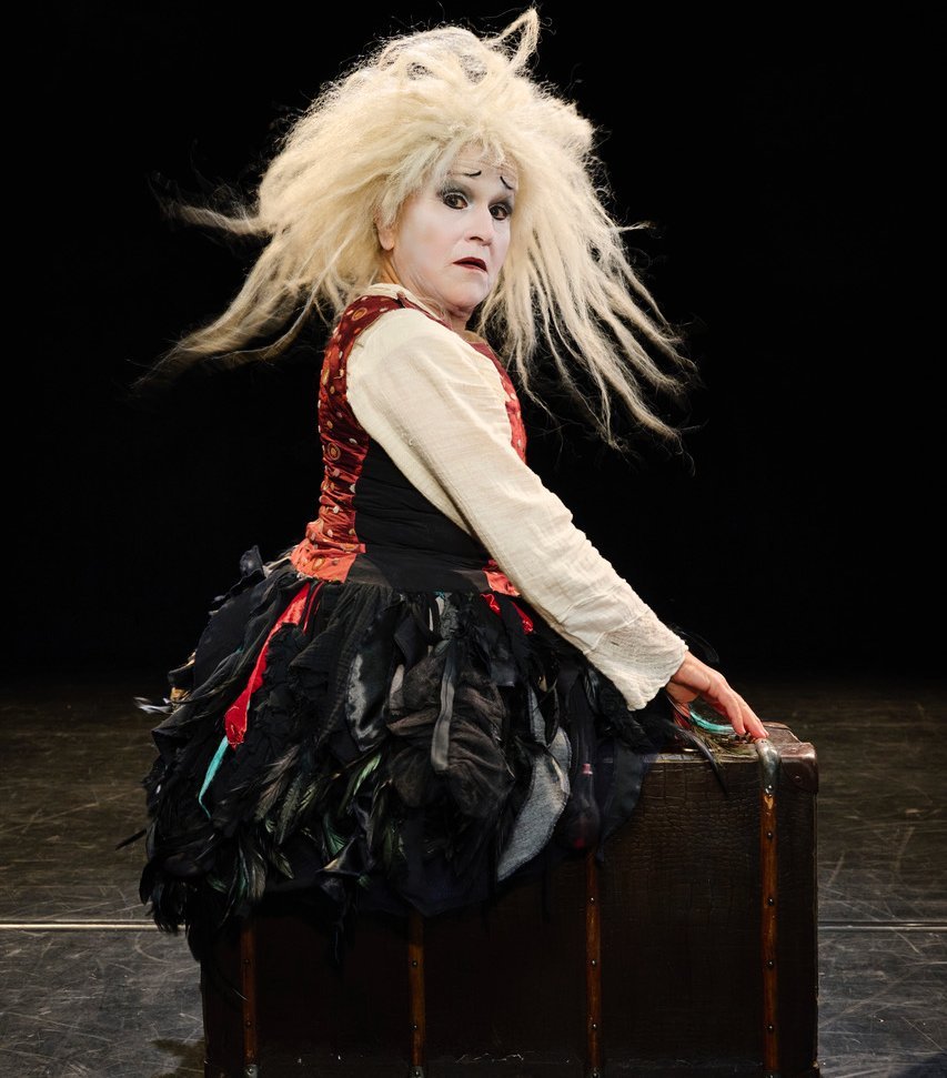 Auf dem Foto ist Gardi Hutter auf einem Koffer sitzend zu sehen.