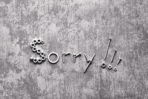 Das Wort "Sorry" aus Schrauben auf einem Beton Hintergrund