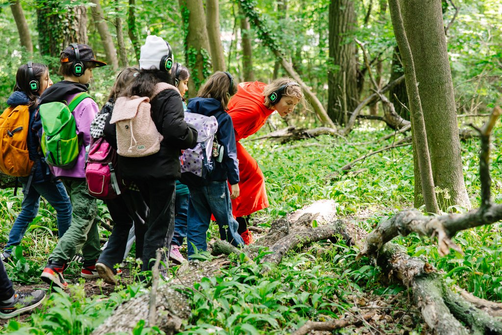 Gruppe Jugendlicher mit Kopfhörern im Wald