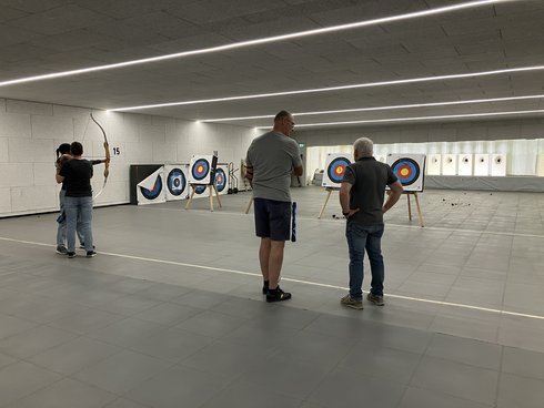 Mitglieder des Schützenvereins erklären, wie man mit dem Bogen schießt.