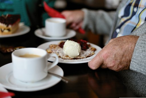 Tisch gedeckt mit zwei Kaffeetassen und Kuchen