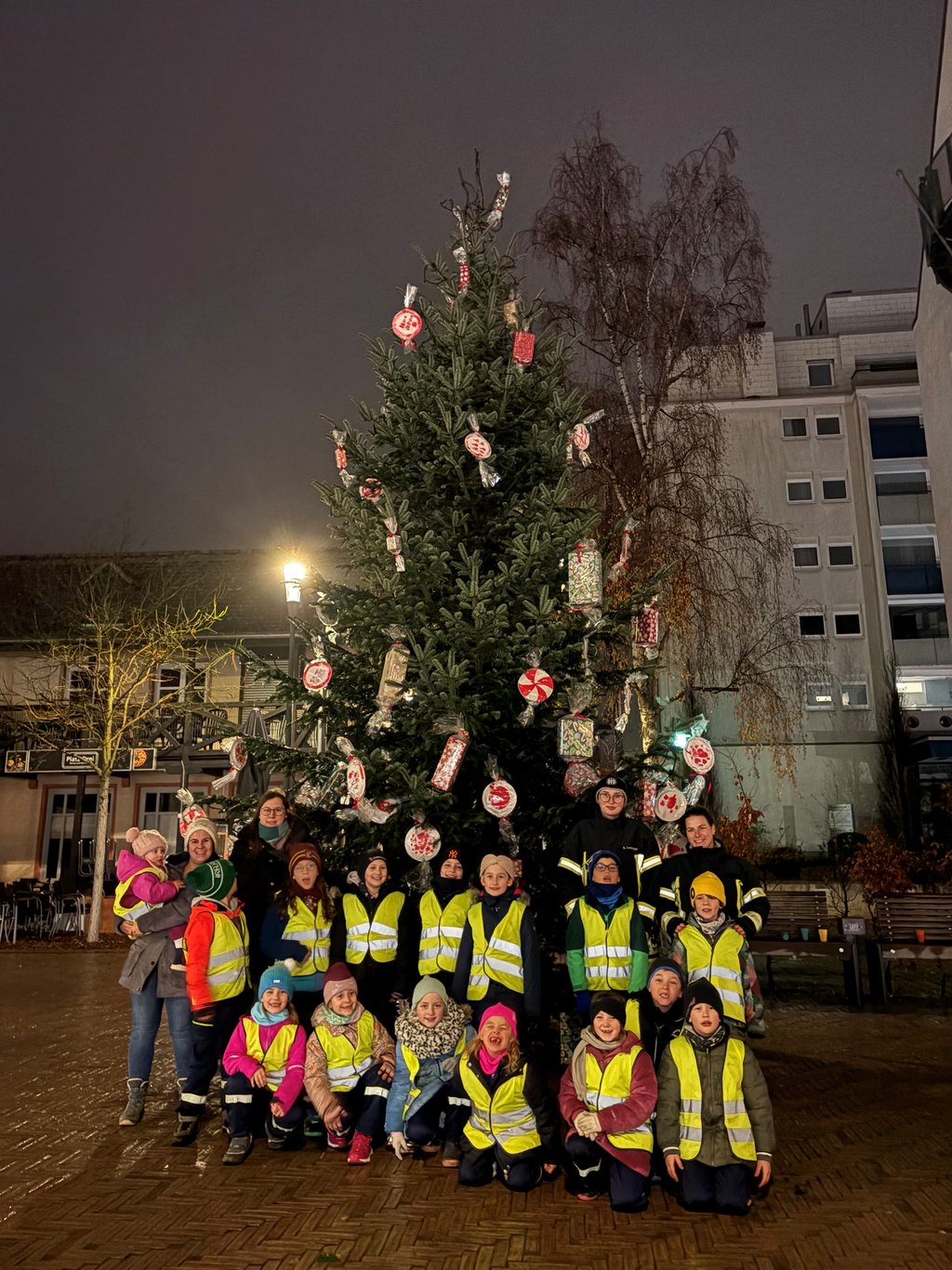 Die Kinder der Mini-Feuerwehr Burgholzhausen mit Ihren Betreuenden vor dem festlich geschmückten Weihnachtsbaum am Landgrafenplatz.