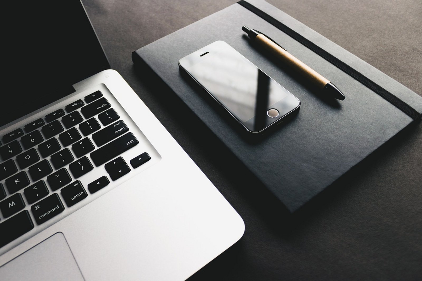 Laptop-Tastatur, Handy, Stift und Kalender