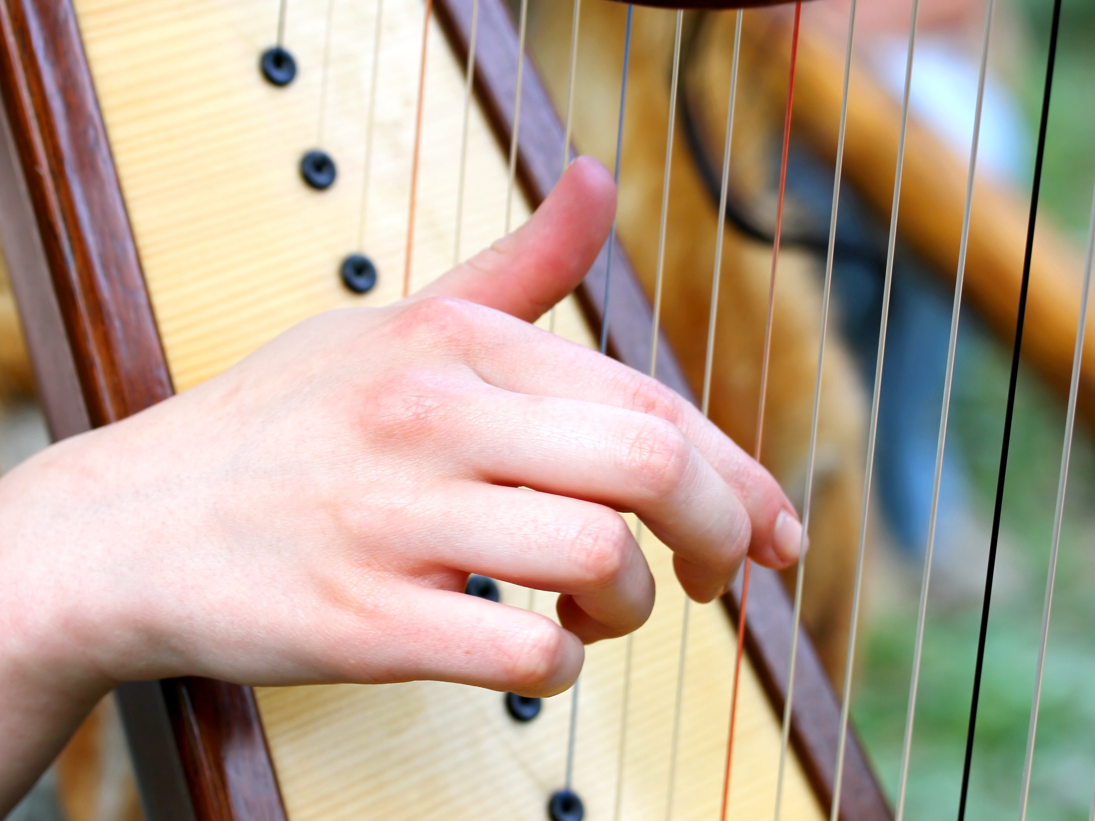 Eine Hand zupft eine Harfe