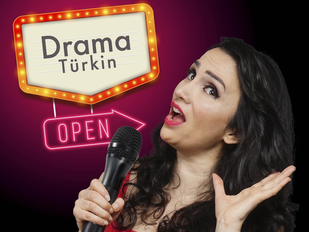 Auf dem Bild ist Senay Duzcu mit Mirkofon in der Hand zu sehen.