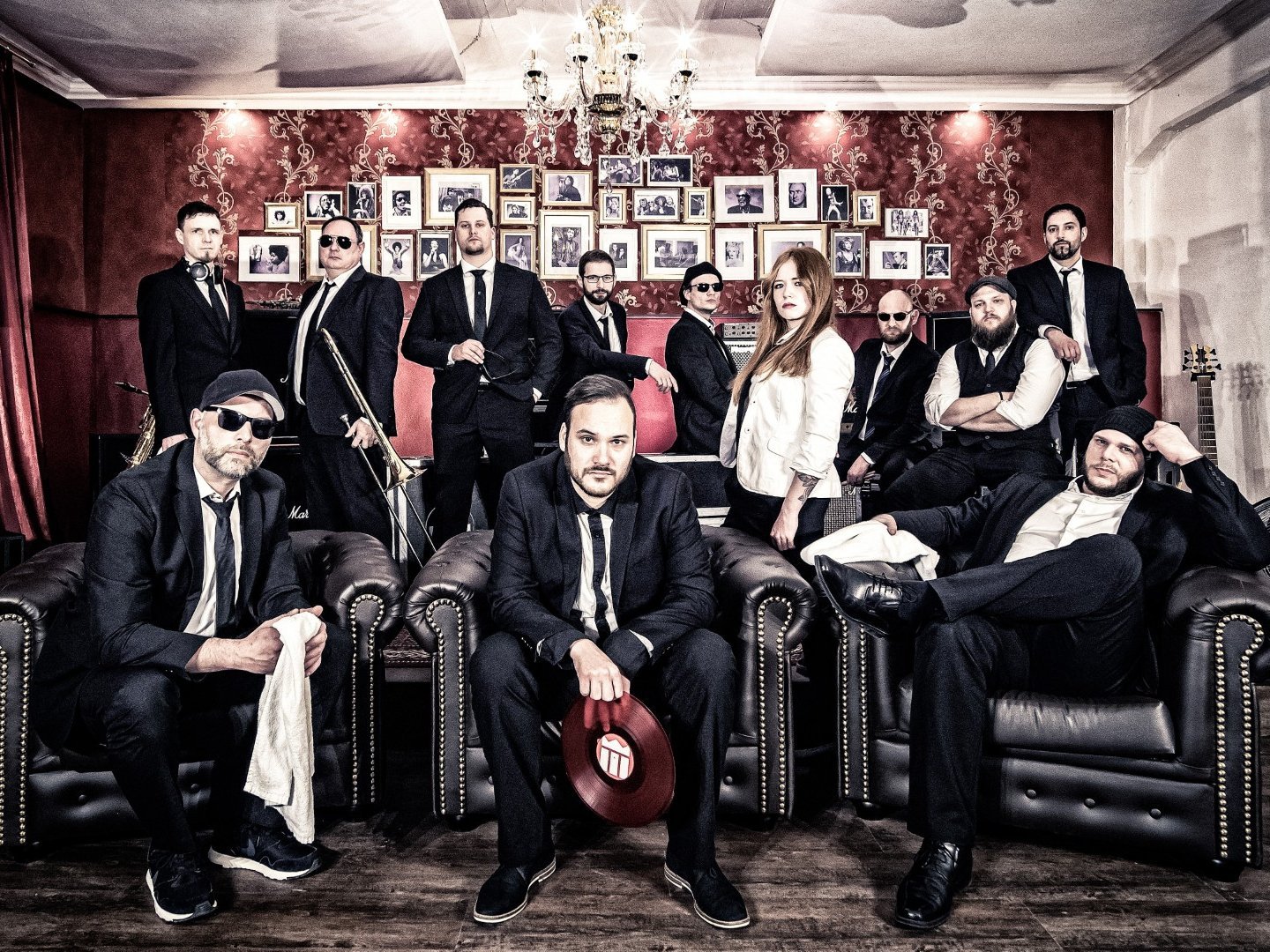 Auf dem Bild sind alle Mitglieder der Music Monks zu sehen. Alle tragen schwarze Kleidung mit weißen Akzenten.