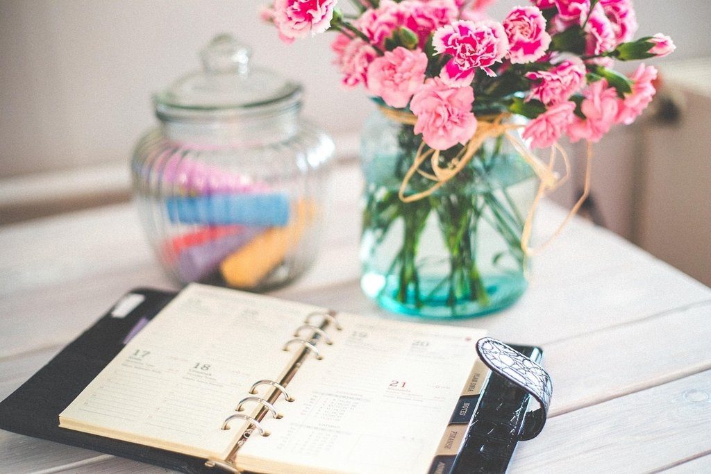 Kalender und Blumen in einer Vase und Glastop.
