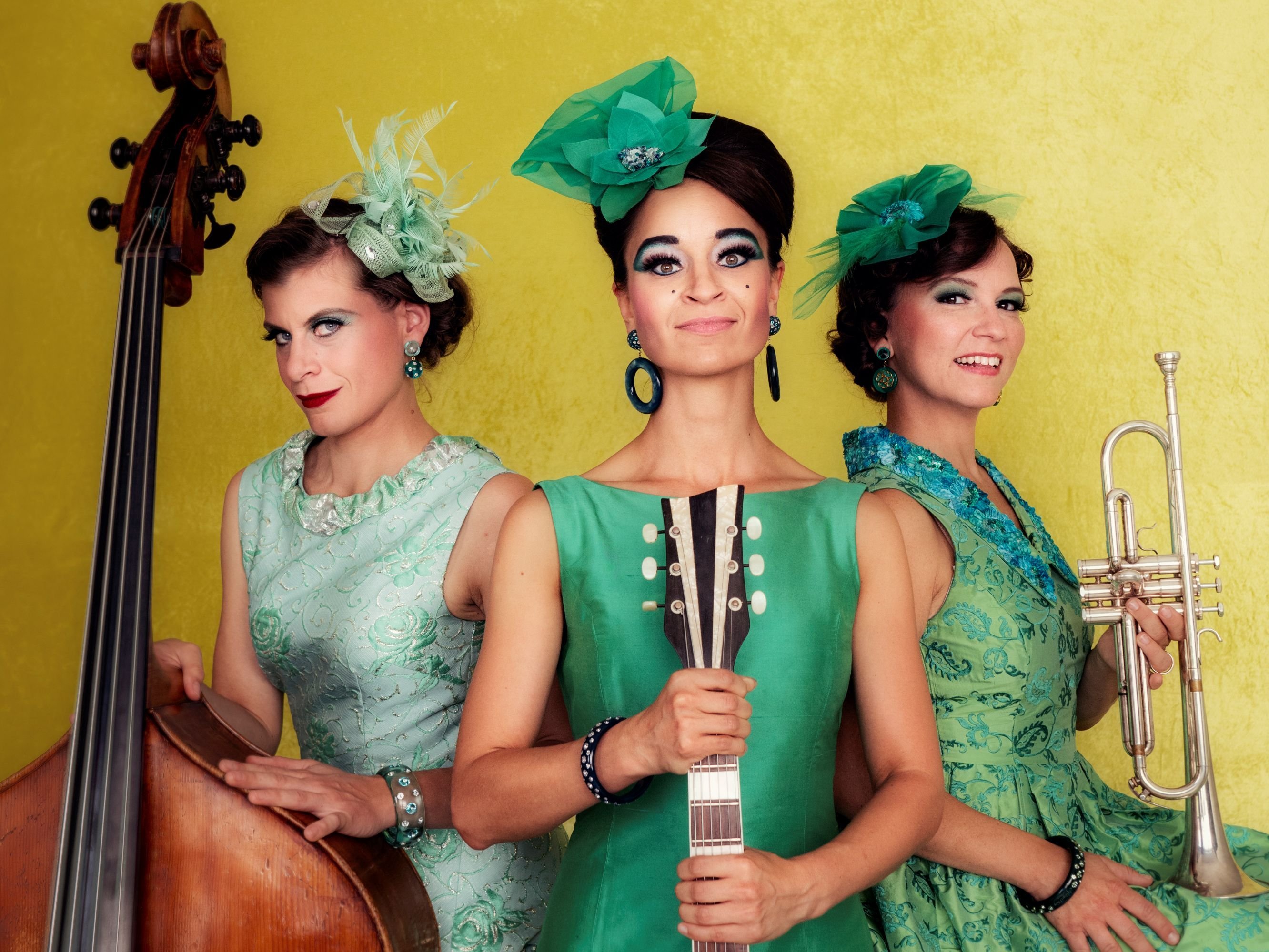 Auf dem Bild sind die drei Musikerinnen von Zucchini Sistaz in grünen Kleidern zu sehen.