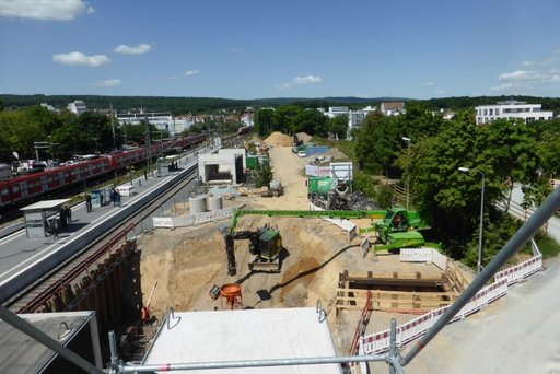 Ein Bagger der ein Loch neben den Schienen am Friedrichsdorfer Bahnhof gräbt