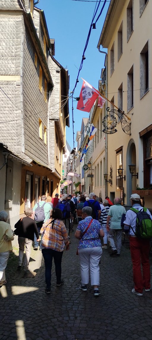 Personengruppe durchquert Gasse in historischer Altstadt