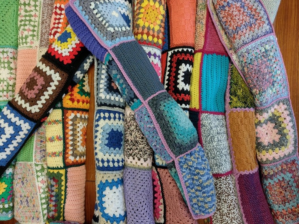 Zu sehen sind eine butne Auswahl and handgemachten Patchworkdecken.