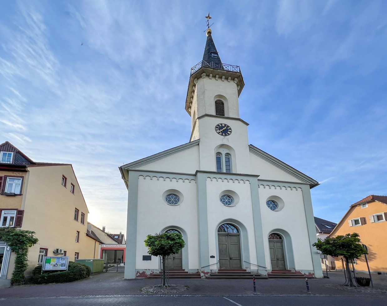 Auf der Darstellung ist die Front der Evangelischen Kirche mit dem Haupteingang zu sehen.