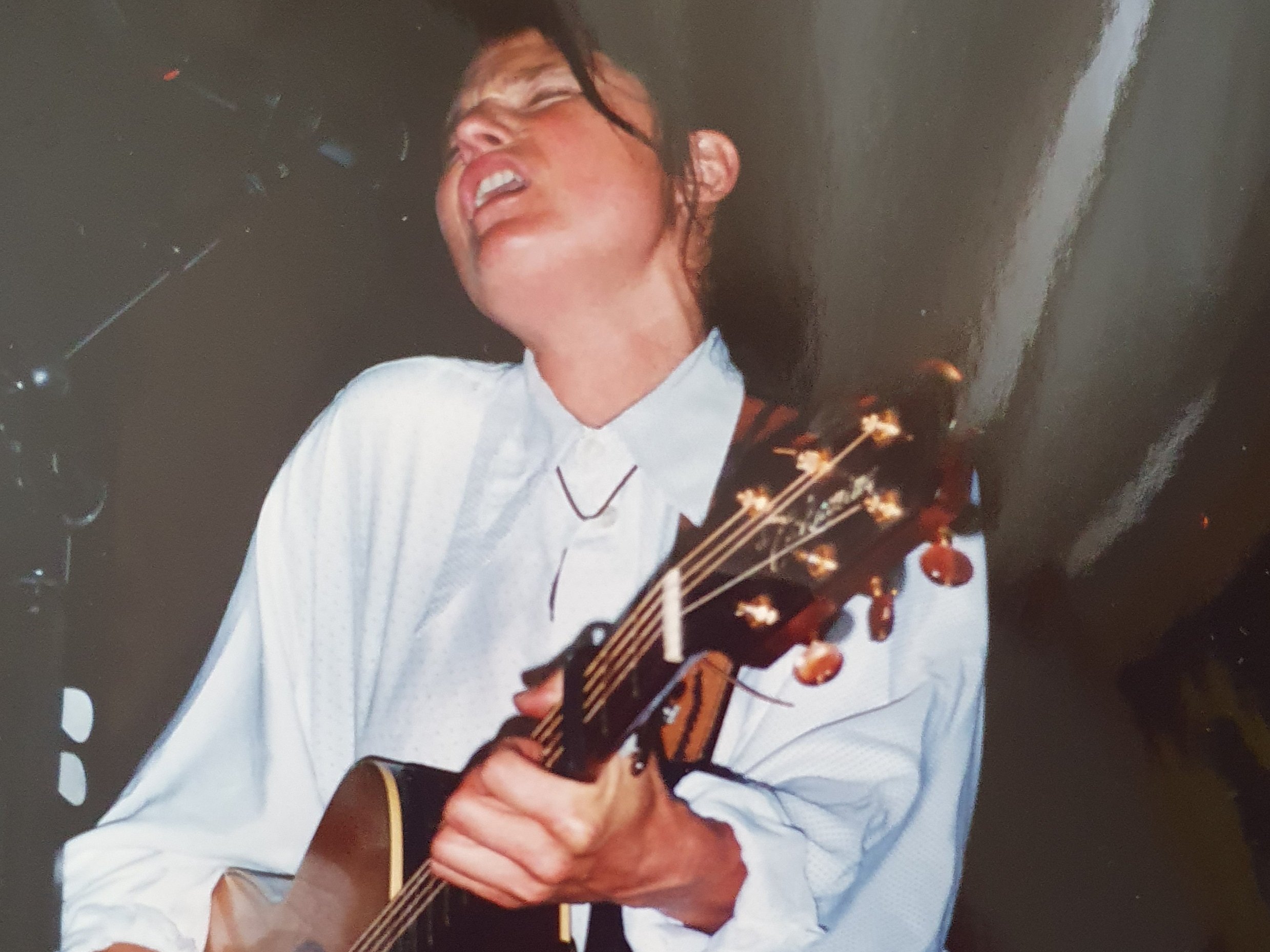 Auf dem Bild ist Barbara Clear Gitarre spielend und singend zu sehen.