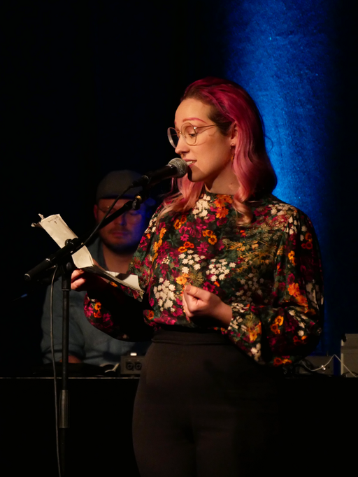 Auf dem Bild ist Katharina Marosz mit Skript und Mikro zu sehen.