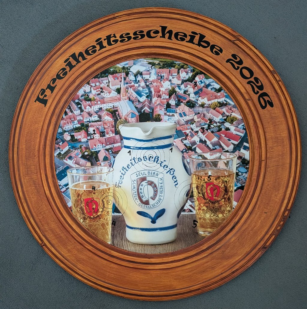 Holzscheibe, auf der ein Bembel, zwei Apfelweingläser und der Ausschnitt eines Luftbildes von Seulberg abgebildet sind.