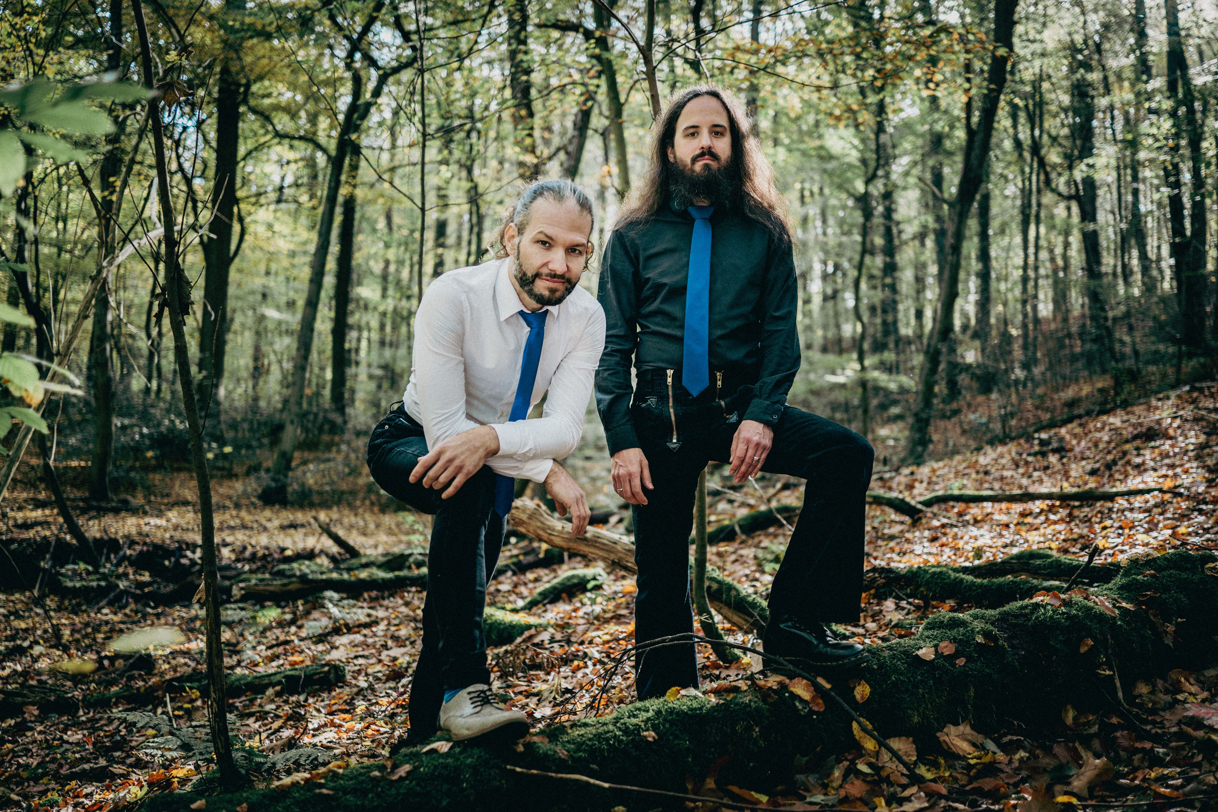 Auf dem Bild ist das Duo Stout mit seinen Instrumenten im Wald zu sehen.