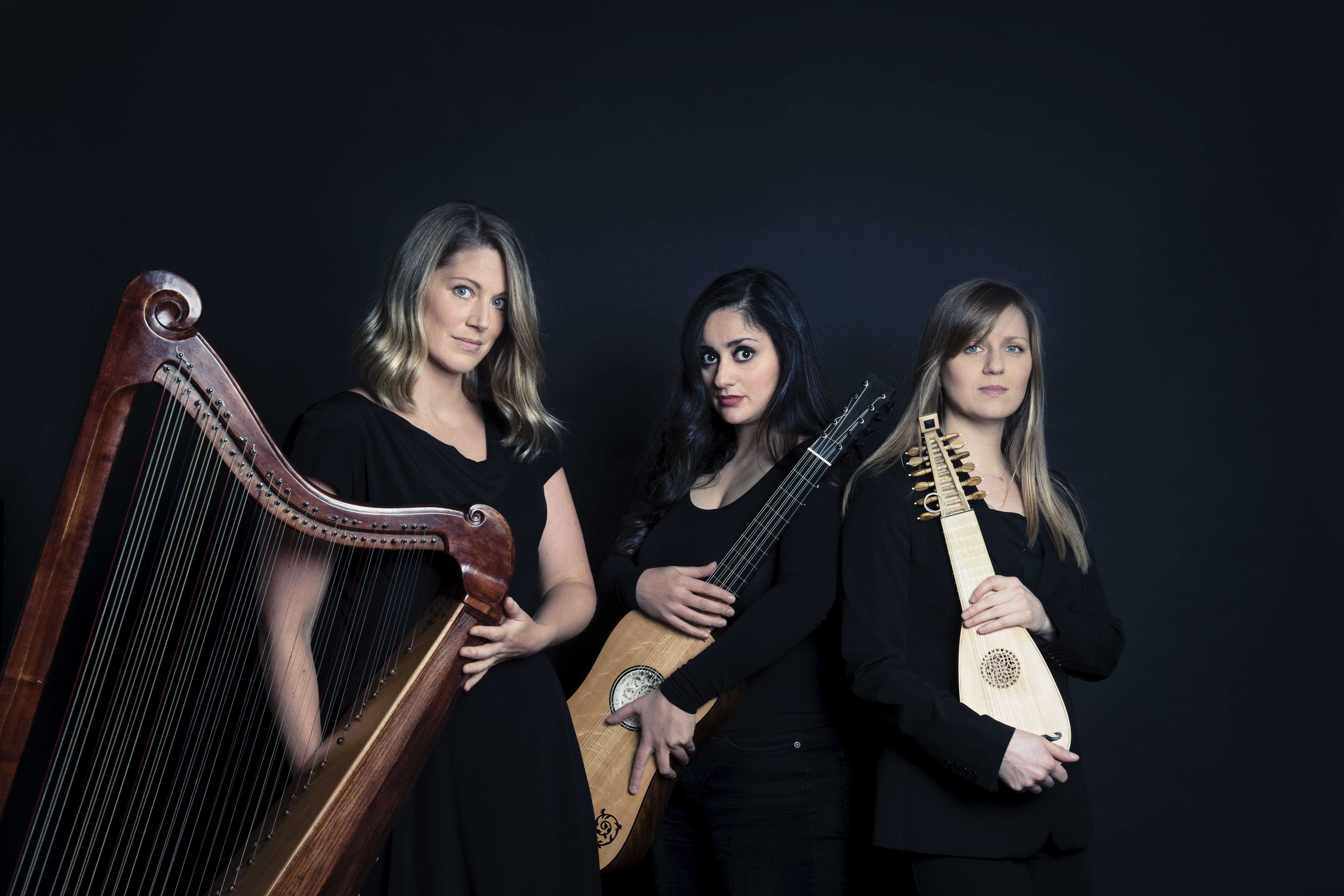 Auf dem Bild sind drei Musikerinnen mit ihren Saiteninstrumenten zu sehen. 